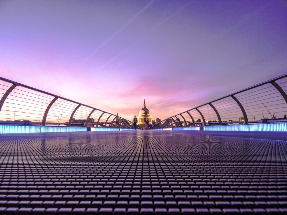 This is a modern artistic photograph looking north over the Millennium Bridge to the dome of St Paul's Cathedral in London, England.