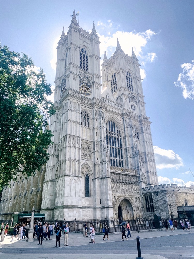 A beautiful alternate view of Westminster Abbey is created by the sun behind the western facade. Brilliantly illuminated clouds and blue sky contrast with the facade's shadowed palette.