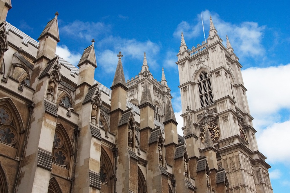 An attractive low-angle photograph of Westminster Abbey's northern facade showing its buttresses and Gothic architecture.