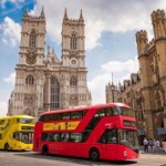 Two busses and many people outside Westminster Abbey.